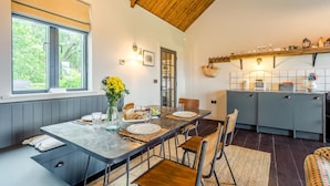 A modern kitchen with a dining area, wooden ceiling, and large windows. - 1 Bed in Wickhambrook (oc-tosh) (Wickhambrook)