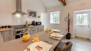 A modern kitchen with a central island, a built-in oven, and a stainless steel range hood. - 2 Bed in Gilsland (oc-t32230) (Waterhead)