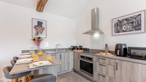 A modern kitchen with grey cabinetry, a built-in oven, a microwave, and a coffee maker. - 2 Bed in Gilsland (oc-t32230) (Waterhead)