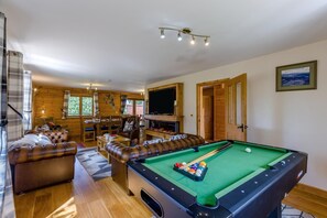 A pool room with a pool table, leather sofas, a television, and a fireplace. - 9 Bed in Brecon (oc-cvelo) (Crai)