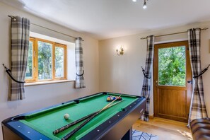A pool table with balls and cues, a window with curtains, a door with curtains, and a small table with a chair. - 9 Bed in Brecon (oc-cvelo) (Crai)