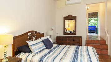 Un dormitorio con cama, cómoda, espejo y lámpara.