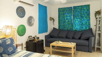 Een moderne woonkamer met een grijze bank, een houten salontafel en decoratieve wandkunst.