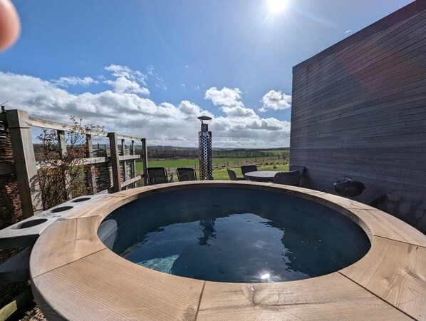 A hot tub with a wooden deck, a view of the countryside, and a clear sky. - 2 Bed in Kelso (oc-gd1860) (Kelso)