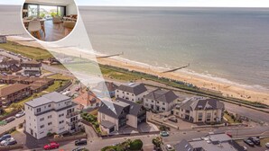 Ein Küstenwohngebiet mit modernen Häusern, einem Strand und Blick aufs Meer.