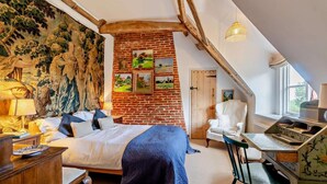 A bedroom with a large bed, a desk, a chair, a lamp, and a mural on the wall. - 4 Bed in Sudbourne (oc-w32267) (Sudbourne)
