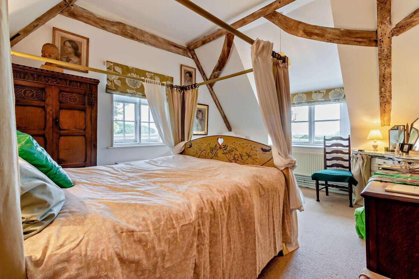A bedroom with a bed, wooden headboard, and a window with curtains.