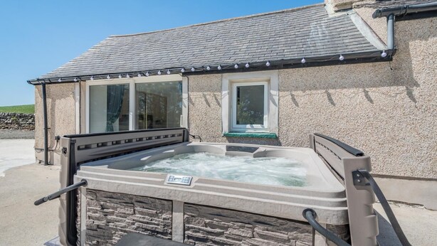 A spa area with a hot tub, stone walls, and a window. - 3 Bed in Leswalt (oc-g32241) (Leswalt)