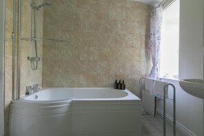A modern bathroom with a freestanding bathtub, a shower area, and a window with a curtain. - 3 Bed in Marazion (oc-smccbl) (Marazion)