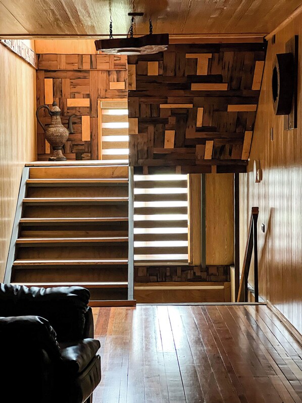 Una escalera de madera con diseño moderno que sube a un piso superior.