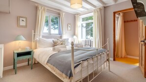 A bedroom with a bed, bedside tables, and a window with curtains. - 2 Bed in Kettlestone (oc-t32268) (Little Snoring)