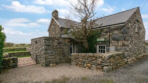 Une ferme en pierre avec une allée en gravier et un panneau indiquant qu’il s’agit d’une ferme.
