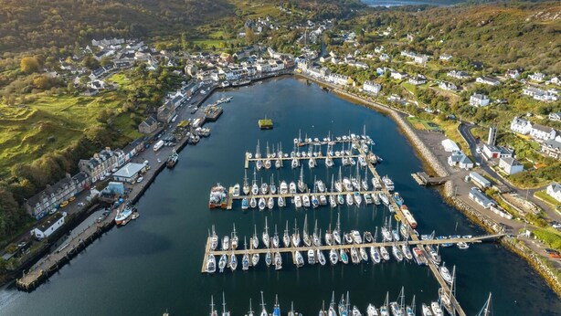 An aerial view of a coastal town with a marina, houses, and hills in the background. - 3 Bed in Clachan (oc-h32242) (Clachan)