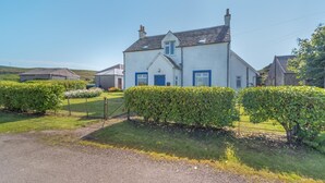 A two-story house with a white exterior and blue doors, surrounded by well-maintained hedges and a gravel driveway. - 3 Bed in Clachan (oc-h32242) (Clachan)