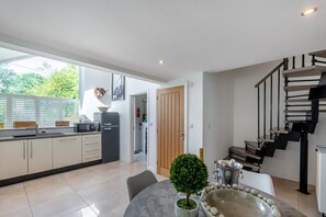 A modern kitchen with a dining area, a staircase, and a view of the outdoors. - 2 Bed in Barbon (oc-b32217) (Barbon)