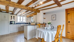 A spacious kitchen with white cabinetry, a central island, and wooden beams on the ceiling. - 5 Bed in Finningham (oc-obhf) (Finningham)
