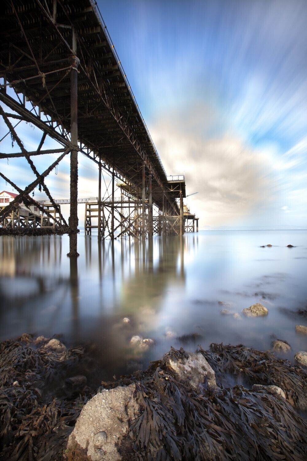 A pier extending into calm waters with a clear sky above.