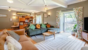 Ein gemütliches Wohnzimmer mit einer Couch, einem Couchtisch und einem Bücherregal voller Bücher.