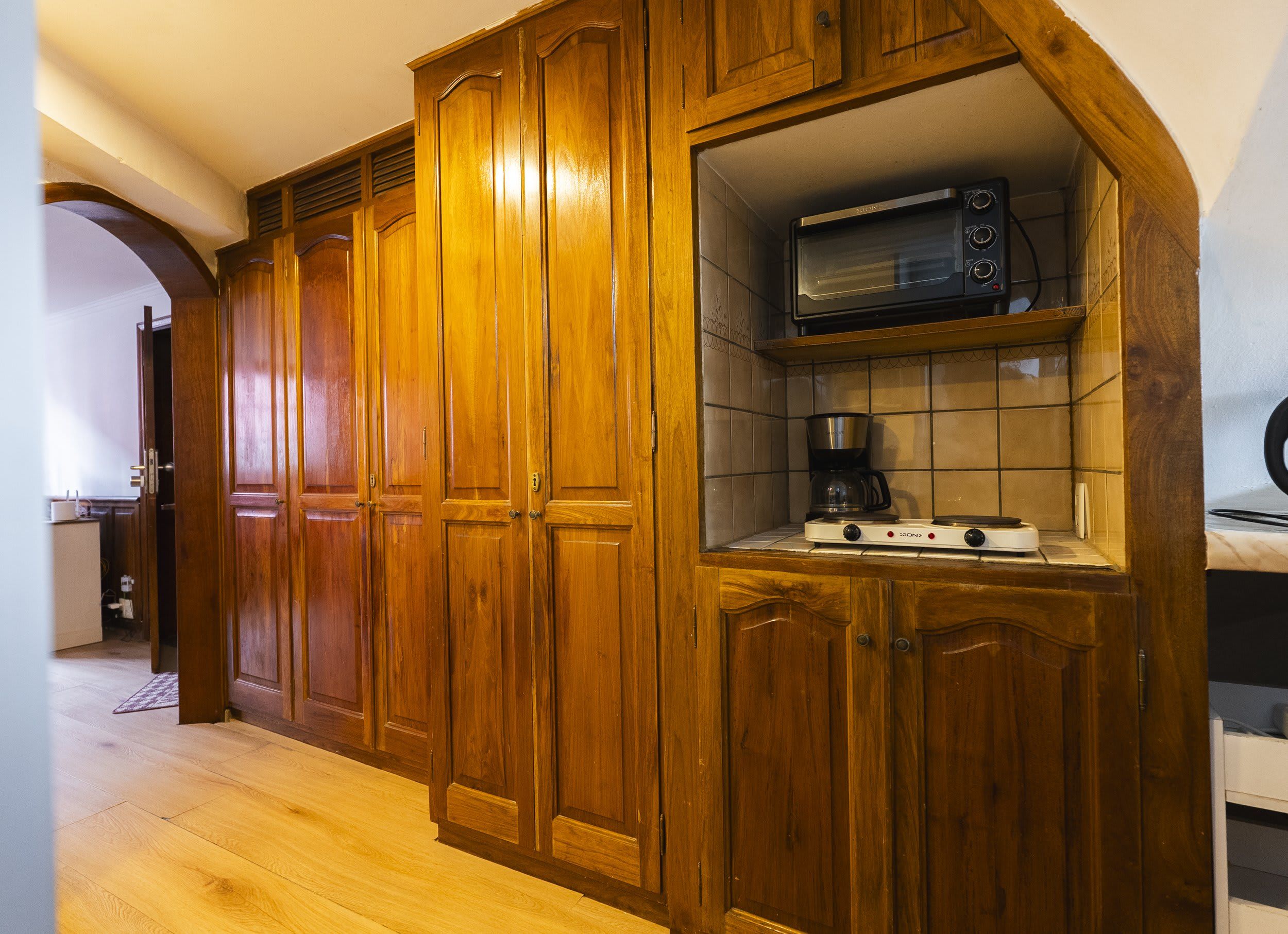 A kitchen with wooden cabinets, a microwave, and a coffee maker.