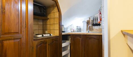 Une cuisine avec des armoires en bois, un four à micro-ondes et une cuisinière.