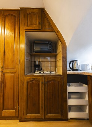 A kitchen with wooden cabinets, a built-in microwave, a coffee maker, and a kettle on the countertop. - Casa Yacumenza Ground Floor CoastFlat (Montevideo)