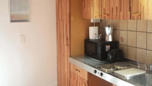 Eine Küche mit Holzausstattung, einer Mikrowelle, einem Toaster und einem Spülbecken.