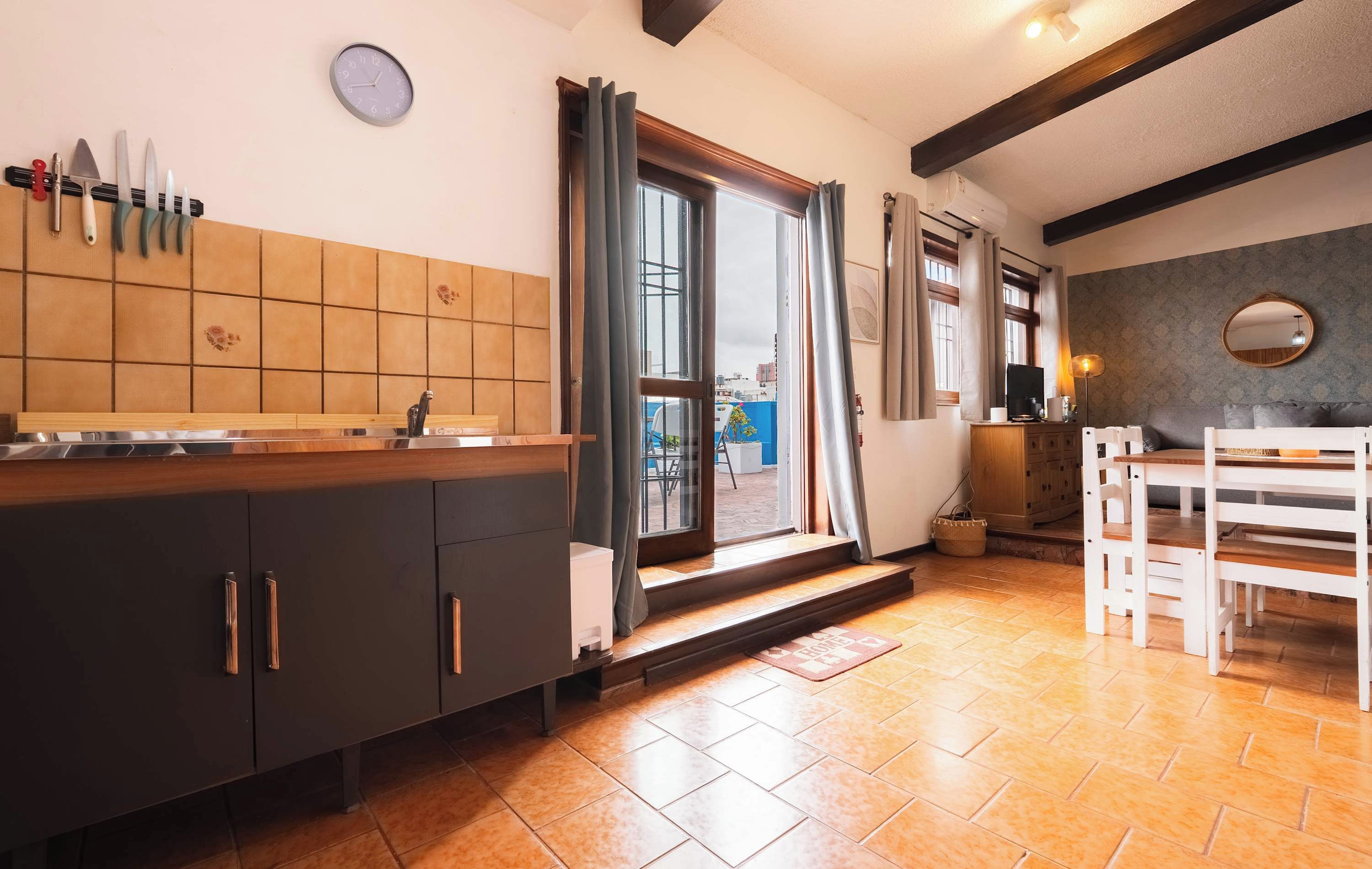 A kitchen with a wooden countertop, a sink, and a window with curtains.