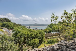 A coastal town with houses, a beach, and a view of the sea and hills.