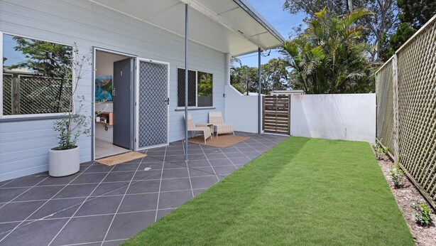 A modern house with a covered patio, a fenced backyard, and a well-maintained lawn. - Unit tucked away in a quiet street (Amity)