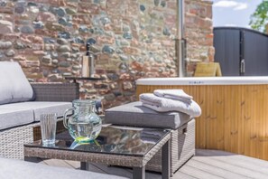 A glass-top table with a pitcher and a glass, a wicker sofa, and a wooden cabinet with towels. - 1 Bed in Dalston (oc-s32206) (Dalston)
