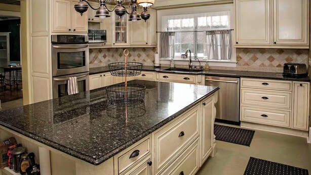 A spacious kitchen with granite countertops, white cabinetry, and a central island. - Champlin House at Keuka Lake (Hammondsport)