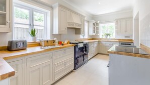 A spacious kitchen with white cabinetry, a built-in oven, and a countertop with a toaster and a basket. - 4 Bed in Holt (oc-a32207) (Holt)