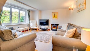 A cozy living room with a fireplace, a television, and comfortable seating. - 4 Bed in South Walsham (oc-2081) (South Walsham)