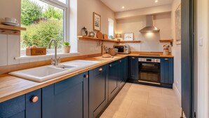 A modern kitchen with a large window, built-in appliances, and a wooden countertop. - 4 Bed in Ruswarp (oc-d32269) (Ruswarp)
