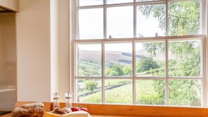 A kitchen with a large window overlooking a rural landscape. - 4 Bed in Horsehouse (oc-c32282) (Horsehouse)