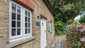 Un bâtiment en pierre avec une porte blanche et une fenêtre à carreaux.