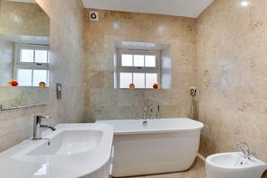Ein modernes Badezimmer mit einer freistehenden Badewanne, einem Waschbecken und einem Bidet.