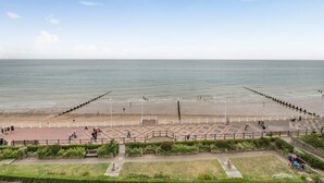 A coastal promenade with a paved walkway, grassy areas, and a view of the sea. - 3 Bed in Bridlington (oc-o32293) (Bridlington)