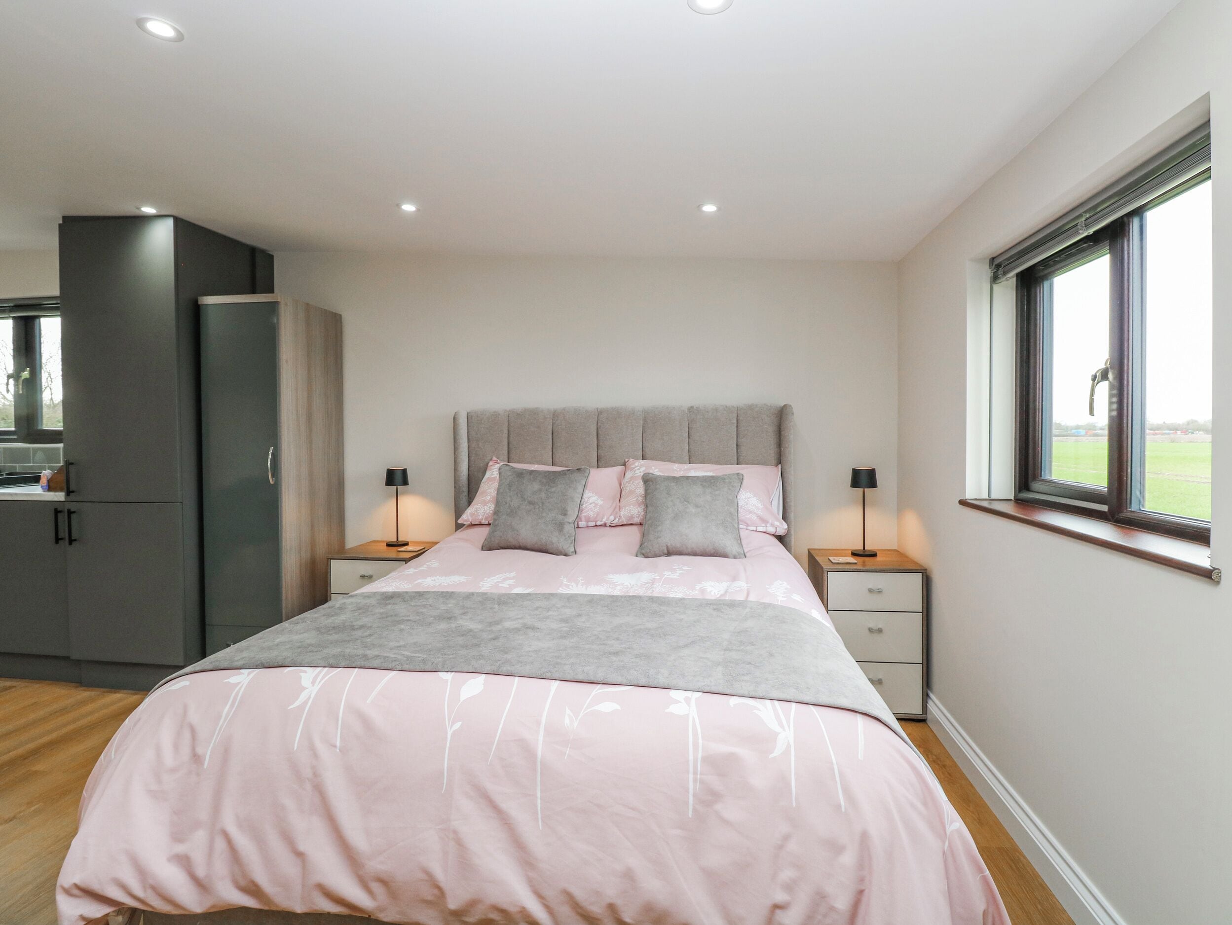 A bedroom with a bed, bedside tables, a wardrobe, and a window.