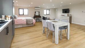 Um apartamento moderno com cozinha, sala de jantar e cama.