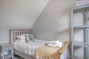 A bedroom with a single bed, a nightstand, a bedside table, and a built-in shelving unit. - 4 Bed in Amble (oc-gd1868) (Amble)