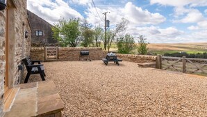 A stone building with a gravel patio, outdoor seating, and a view of the countryside. - 2 Bed in Nenthead (oc-s32235) (Alston Moor)