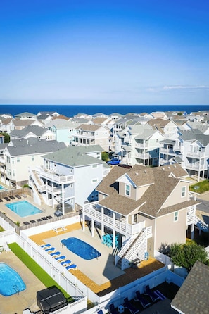 A coastal residential area with multiple houses, a swimming pool, and a view of the ocean. - 3min Walk to Beach with Heated Pool in Ocean Sands (Corolla)
