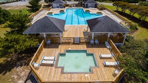 A large swimming pool with a wooden deck, lounge chairs, and a small hot tub. - 3min Walk to Beach with Heated Pool in Ocean Sands (Corolla)