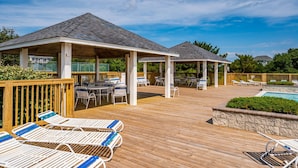 A wooden deck with lounge chairs, a pool, and covered areas with tables and chairs. - 3min Walk to Beach with Heated Pool in Ocean Sands (Corolla)
