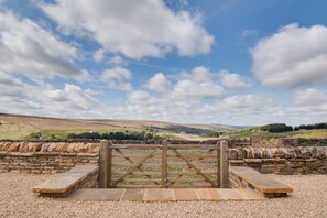 A stone gate leading to a rural landscape with rolling hills and a clear sky. - 5 Bed in Nenthead (oc-f32234) (Alston Moor)