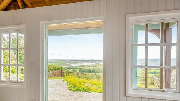 A room with a view of a garden and a distant landscape through a door. - 1 Bed in Llanfair (oc-b32109) (Llanfair)