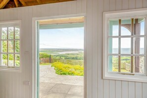 Une pièce donnant sur un jardin et offrant une vue lointaine sur le paysage, vue à travers une porte.