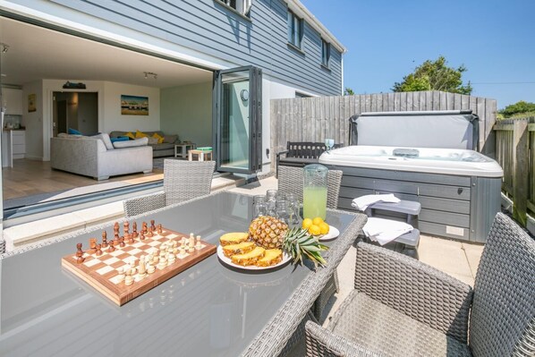 Une terrasse extérieure avec un jeu d’échecs, des tranches d’ananas et un jacuzzi.