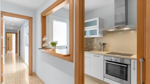 Een moderne keuken met een Bosch oven, een raam met uitzicht en een spiegel met houten lijst.